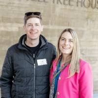 Two event attendees standing together and smiling for photo